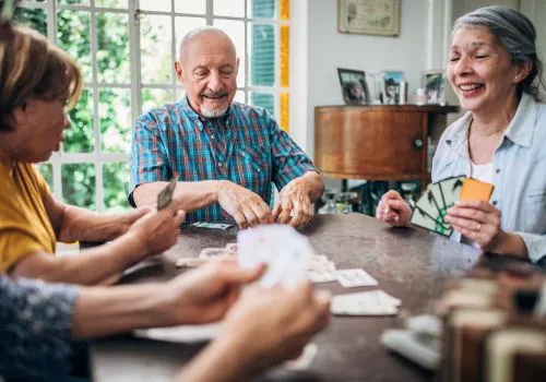 A game of spades is enjoyed by a group of elderly friends