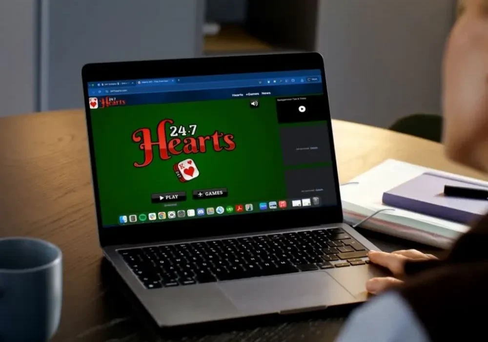 A game of Hearts from 247 Hearts open in a laptop