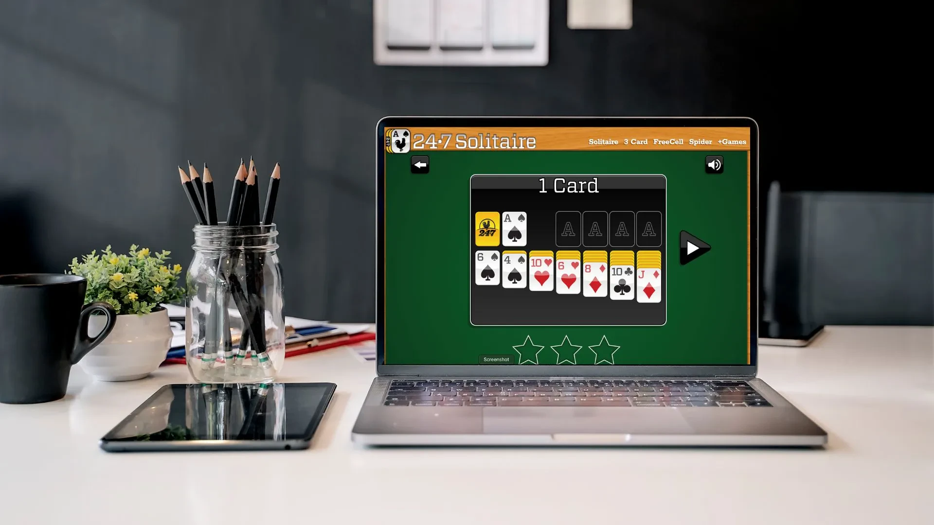A laptop screen with the 247 Solitaire game open