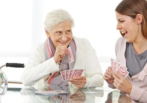 A grandmother and presumably a younger family member playing card games for two